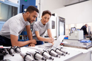 Man and woman overseeing the thixomolding process