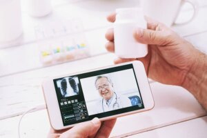 holding cell phone with doctor visit and pill bottle