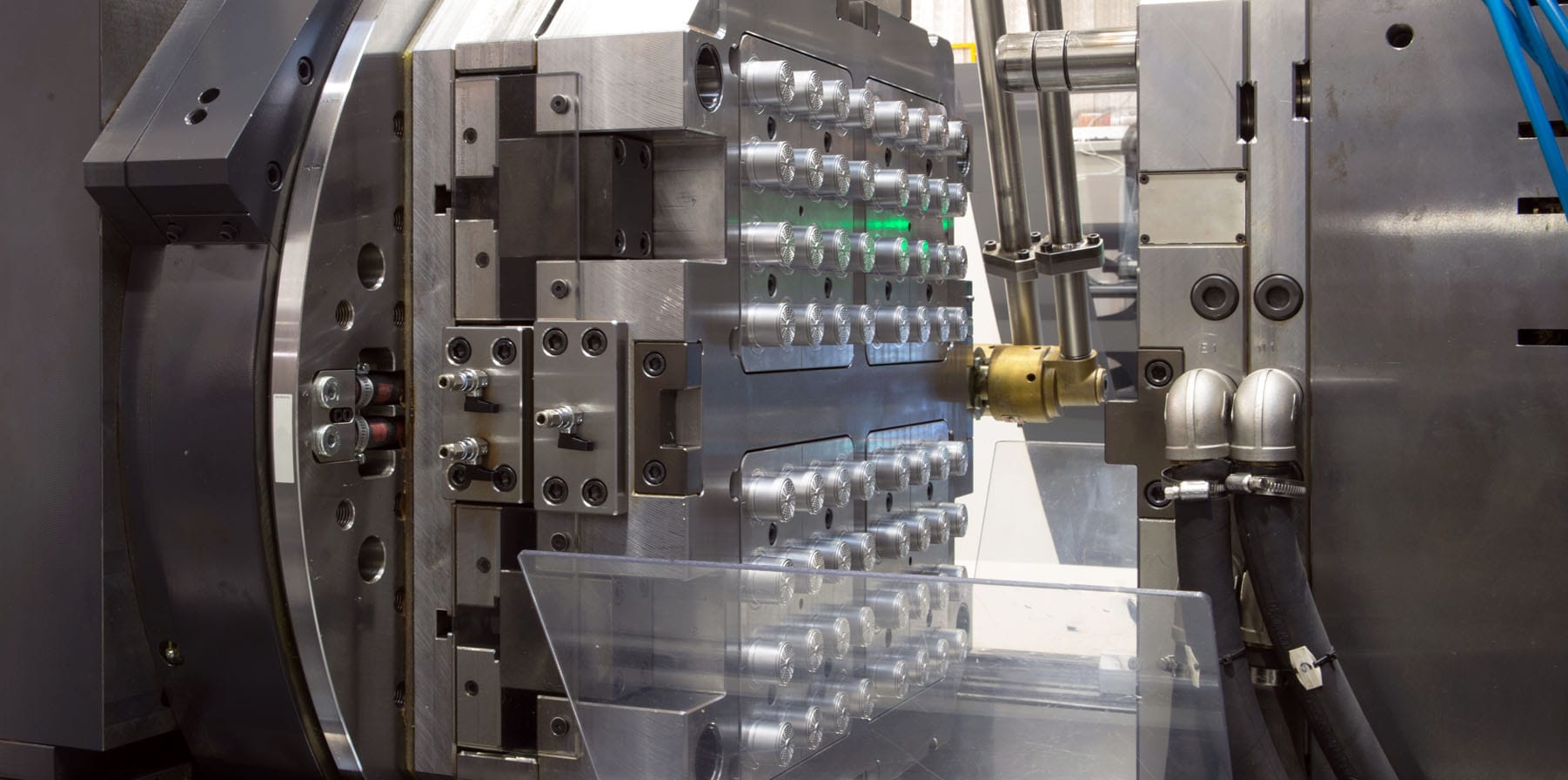 A close up image of advanced injection molding technologies machines in a large factory