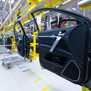 An image of car doors being manufactured in a large manufacturing facility