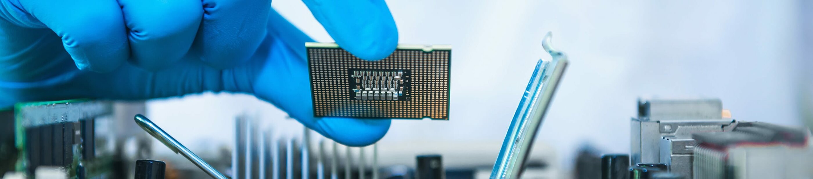 hand in blue gloves holding computer chip