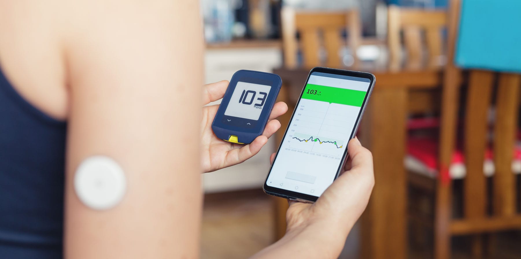 Woman comparing result of glucose level check on the traditional glucometer and on the mobile phone reading from a remote connected health sensor mounted on her forehand