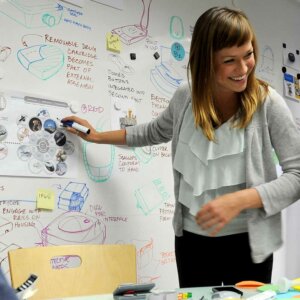 woman pointing to white board
