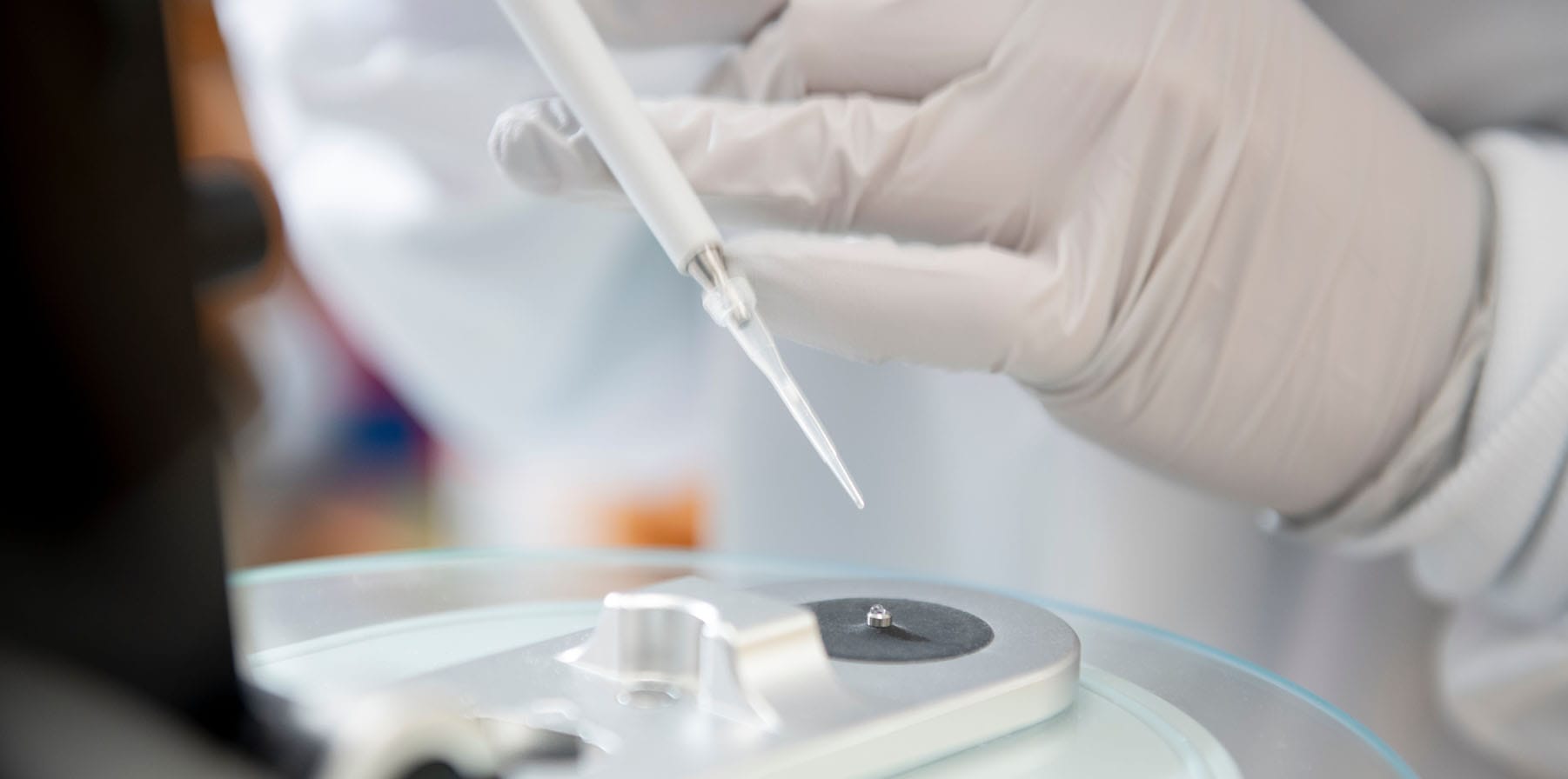 Scientist hand using pipette with micro volume spectrophotometer used in in vitro diagnostics