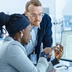 man and woman looking at computer part