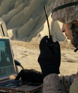 man on walkie talkie looking at computer screen