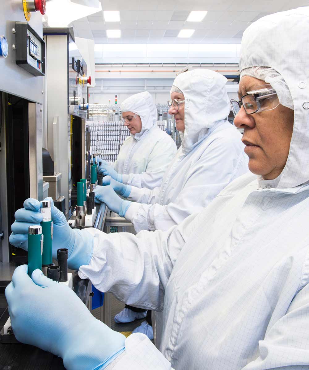 women in white hazmat suit working on machines