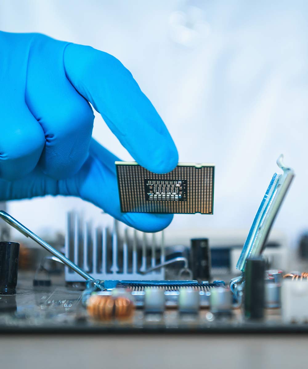 hand in blue gloves holding computer chip