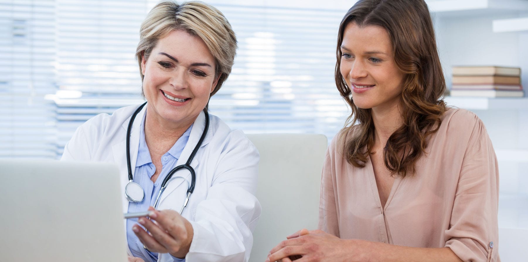 Doctor discussing Product Instructions for Use (IFU) with female patient in front of a laptop