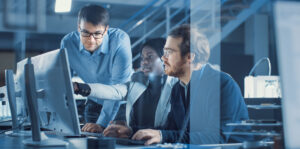 Manufacturing team reviewing software bill of materials on a computer.