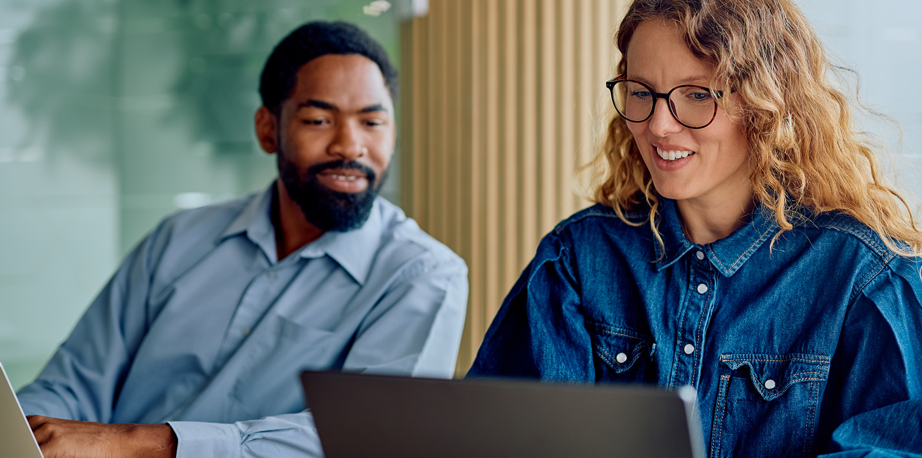 Two coworkers looking at a computer